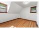 Spacious attic bedroom featuring hardwood floors, natural light, and unique angled ceilings at 3039 W 22Nd Ave, Denver, CO 80211