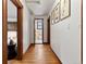 Hallway with hardwood floors and wood trim, offering views into other rooms at 3039 W 22Nd Ave, Denver, CO 80211