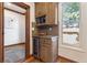 Kitchen wet bar with wine cooler, built-in microwave, and natural wood cabinets at 3039 W 22Nd Ave, Denver, CO 80211