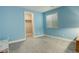 Light blue bedroom with gray carpet, a closet, and window at 10256 Olathe Way, Commerce City, CO 80022