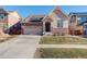 Two-story house with stone and siding, two-car garage, and landscaped yard at 10256 Olathe Way, Commerce City, CO 80022