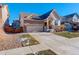 Two-story house with stone and siding, two-car garage, and landscaped yard at 10256 Olathe Way, Commerce City, CO 80022