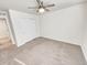 This carpeted bedroom features a ceiling fan, a closet, and neutral walls at 14880 Chicago St, Parker, CO 80134