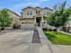 Charming two-story home with stone accents, a well-manicured lawn, and a wide driveway leading to a two-car garage at 14880 Chicago St, Parker, CO 80134