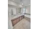 Bathroom with double sink vanity with granite counters and a soaking tub at 14880 Chicago St, Parker, CO 80134