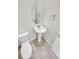 Clean powder room featuring a pedestal sink, toilet, and neutral tile flooring at 14880 Chicago St, Parker, CO 80134