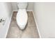 White toilet against neutral-colored tile flooring at 14880 Chicago St, Parker, CO 80134