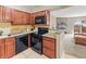 Bright kitchen featuring tile floors, dark cabinets, granite countertops, and black appliances, open to the living room at 430 Zang St # 4-103, Lakewood, CO 80228