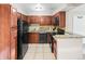Bright kitchen featuring tile floors, dark cabinets, granite countertops, and black appliances at 430 Zang St # 4-103, Lakewood, CO 80228