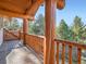 Exterior balcony with log beams and stone floors provides a tranquil outdoor space with surrounding tree views at 7076 Boreas Rd, Larkspur, CO 80118