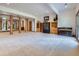 Spacious basement with natural wood support beams, carpeted flooring, and custom built-in shelving at 7076 Boreas Rd, Larkspur, CO 80118