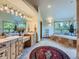 Spacious bathroom featuring double vanities, a corner soaking tub, and bright natural light from multiple windows at 7076 Boreas Rd, Larkspur, CO 80118