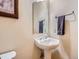 Charming powder room features textured walls, and a pedestal sink, creating an inviting space at 7076 Boreas Rd, Larkspur, CO 80118