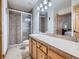 Bathroom featuring tile shower with glass door, solid surface counter and cabinets at 7076 Boreas Rd, Larkspur, CO 80118