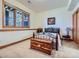 Bedroom featuring a decorative wrought iron bed, a cedar chest, and natural light from the adjacent window at 7076 Boreas Rd, Larkspur, CO 80118