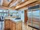 Well-equipped kitchen with stainless steel appliances, custom wood cabinets, and tile countertops offers functionality at 7076 Boreas Rd, Larkspur, CO 80118