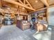 Inviting living room with a stone fireplace, wood beams, and an open layout to kitchen and dining at 7076 Boreas Rd, Larkspur, CO 80118