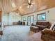 A spacious living room with a vaulted wood ceiling, natural light, and comfortable seating arrangements at 7076 Boreas Rd, Larkspur, CO 80118