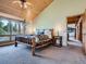 Cozy main bedroom featuring a rustic log bed frame, tongue and groove ceiling, and bright natural light at 7076 Boreas Rd, Larkspur, CO 80118