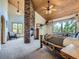 Spacious main bedroom with a stone fireplace, wood ceilings, and natural light creates a serene retreat at 7076 Boreas Rd, Larkspur, CO 80118