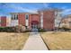 Brick apartment building with a red awning over the entrance and manicured landscaping at 320 S Ames St # 8, Lakewood, CO 80226