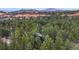 Aerial view of a house nestled among the trees and red rocks at 4966 Delaware Dr, Larkspur, CO 80118