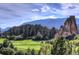 Scenic view of a lush green golf course with rock formations and trees at 4966 Delaware Dr, Larkspur, CO 80118