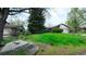 Front lawn with vibrant wildflowers and mature trees frames this charming single-Gathering home at 6463 Brentwood St, Arvada, CO 80004
