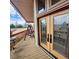 Front porch featuring a wooden deck, decorative glass doors, and outdoor seating at 16659 County Road 4, Brighton, CO 80603