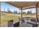 Outdoor patio area with a wood pergola, stone pavers, and comfortable seating area with beautiful landscaping at 24608 E Moraine Pl, Aurora, CO 80016