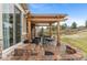 Inviting backyard patio with stone pavers, pergola, outdoor furniture, landscaping, and lots of room for entertaining at 24608 E Moraine Pl, Aurora, CO 80016