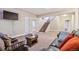This basement features a staircase, carpet, sofas, and a television at 24608 E Moraine Pl, Aurora, CO 80016