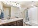 Well-lit bathroom with a double sink vanity, a large mirror and a shower-tub combination with decorative curtain at 24608 E Moraine Pl, Aurora, CO 80016