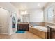This bathroom features a tub, large mirror, double vanity, and walk-in closet at 24608 E Moraine Pl, Aurora, CO 80016