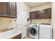Functional laundry room with washer, dryer, sink, and storage cabinets at 24608 E Moraine Pl, Aurora, CO 80016