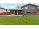 Backyard features a lush lawn, solar panels, a covered patio and a dark grey exterior at 7719 Everett Way, Arvada, CO 80005