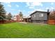 Spacious backyard with a green lawn, dark grey exterior, a covered patio, and solar panels at 7719 Everett Way, Arvada, CO 80005