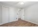 Bedroom featuring wood floors, neutral wall color, a ceiling fan, and a large closet at 7719 Everett Way, Arvada, CO 80005