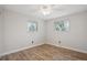 Bedroom features wood floors, neutral wall color, two large windows, and a ceiling fan at 7719 Everett Way, Arvada, CO 80005