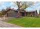 Charming single Gathering home with a well-manicured lawn and lovely mature tree in the front yard at 7719 Everett Way, Arvada, CO 80005