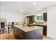 Bright kitchen with stainless steel appliances and granite countertops on a large island with wooden floors at 7719 Everett Way, Arvada, CO 80005