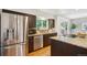 Modern kitchen featuring stainless steel appliances, dark cabinetry, and views to the outdoors through window at 7719 Everett Way, Arvada, CO 80005