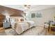 Serene main bedroom with a wood accent wall, plush bedding, and ample natural light, creating a relaxing retreat at 7719 Everett Way, Arvada, CO 80005