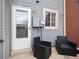Back patio area with a white door, window, and two black chairs at 14272 E Hawaii Cir # B, Aurora, CO 80012