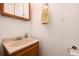 Powder room featuring a neutral-toned vanity, sink, mirror, and fixtures at 14272 E Hawaii Cir # B, Aurora, CO 80012