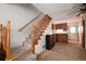 Carpeted living room with a wooden staircase and view into the kitchen at 14272 E Hawaii Cir # B, Aurora, CO 80012