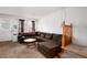 Comfortable living room featuring a brown sectional sofa and a wooden staircase at 14272 E Hawaii Cir # B, Aurora, CO 80012