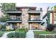 Modern exterior elevation featuring a stone facade, balconies, manicured lawn and inviting entrance at 4566 Xavier St, Denver, CO 80212