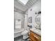 Bathroom with tub and shower, marble tile, wood vanity, sink, toilet, and decor at 450 Yukon St, Lakewood, CO 80226