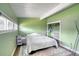 Green bedroom featuring a comfy bed, natural light, and a closet at 450 Yukon St, Lakewood, CO 80226